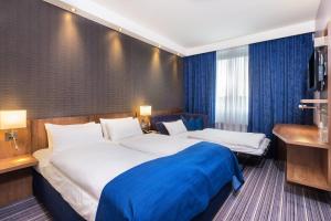 a hotel room with two beds and a television at Holiday Inn Express Friedrichshafen by IHG in Friedrichshafen +104 photos