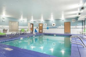 a pool in a hotel room with chairs and tables at  Holiday Inn Express & Suites in Santa Fe