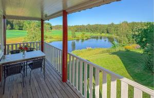 a porch with a table and a view of a lake at Lovely Home In Örkelljunga With Sauna in Orkelljunga