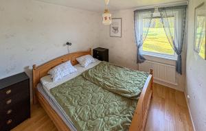 a bedroom with a green bed and a window at Lovely Home In Örkelljunga With Sauna in Orkelljunga