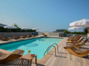 a swimming pool with chairs and a bunch ofitures at Novotel Nice Centre Vieux Nice in Nice +192 photos