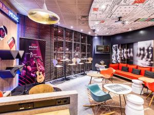 a restaurant with orange and blue chairs and tables at Hotel ibis Porto Gaia in Vila Nova de Gaia