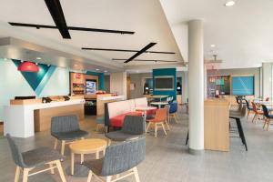 a lobby with chairs and tables and a cafeteria at avid hotel Austin - Round Rock South by IHG in Round Rock