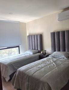 a bedroom with two beds and a window at Apartment in downtown Zapopan in Guadalajara +10 photos