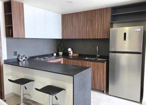a kitchen with a stainless steel refrigerator and black counter top at Apartment in downtown Zapopan in Guadalajara