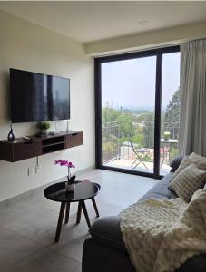 a living room with a couch and a tv and a table at Apartment in downtown Zapopan in Guadalajara