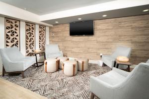 a waiting room with chairs and a flat screen tv at Candlewood Suites Charleston – Mt. Pleasant by IHG in Charleston