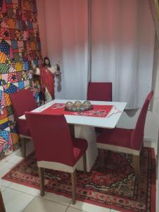 a dining room with a table and red chairs at Casa lai in Rio de Janeiro