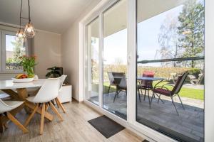 a dining room with a glass door leading to a patio at Strandhaus-3-EG in Marienfelde