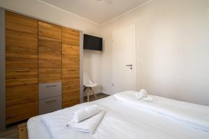 a bedroom with a large white bed with two towels at Strandhaus-3-EG in Marienfelde