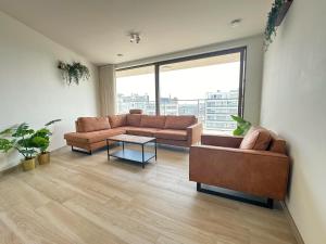 a living room with two couches and a large window at Spacious City Retreat with Balcony in Antwerp