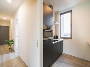 a kitchen with black cabinets and a window at Spacious City Retreat with Balcony in Antwerp