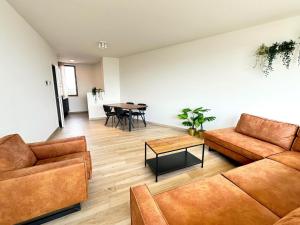 a living room with two couches and a table at Spacious City Retreat with Balcony in Antwerp +19 photos