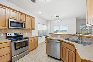 a kitchen with wooden cabinets and stainless steel appliances at Stunning Home near Universal Kids Resort, Frisco in Little Elm