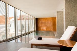 a living room with a white couch and glass windows at Convent Square Lisbon, Vignette Collection by IHG in Lisbon
