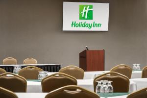 a meeting room with tables and chairs and a podium at Holiday Inn Ontario by IHG in Ontario