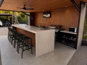 a kitchen with a bar with stools and a counter top at Villas Na-tiva Guanacaste in Plazuela
