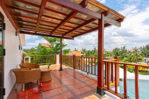 a deck with a wooden pergola and a swimming pool at Salt Villa 5BR Beachfront by HUA in An Bàn (2)