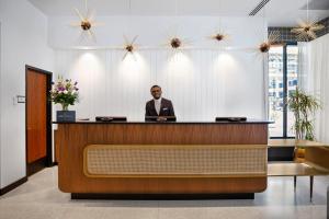 a man in a suit sitting at a reception desk at Hotel Indigo - Minneapolis Downtown by IHG in Minneapolis