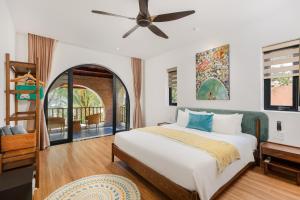 a bedroom with a bed with a ceiling fan at Salt Villa 5BR Beachfront by HUA in An Bàn (2) +39 photos