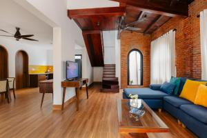 a living room with a blue couch and a tv at Salt Villa 5BR Beachfront by HUA in An Bàn (2)