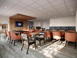 a restaurant with tables and chairs in a room at Holiday Inn Express & Suites Southfield - Detroit in Southfield