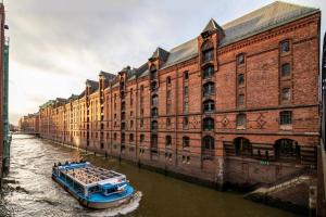 a boat in the water in front of a large building at Garner Hotel Hamburg - Graf Moltke by IHG in Hamburg