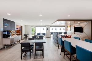 a dining room with tables and chairs and a bar at Holiday Inn Express Wilson I-95 by IHG in Wilson