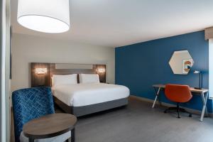 a hotel room with a bed and a desk and chair at Holiday Inn Express Wilson I-95 by IHG in Wilson