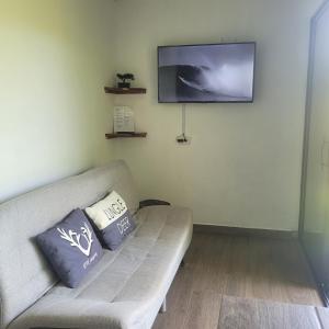 a living room with a couch and a flat screen tv at Torogoz Apartment km61 5 in Jicalapa