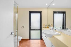 a bathroom with a sink and a toilet and a mirror at Blue Water - BYO Linen in Anglesea +5 photos