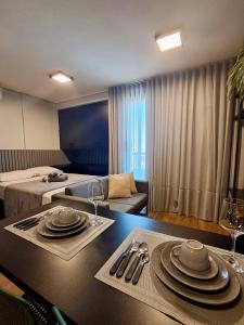a hotel room with a table with plates and wine glasses at Studio Cuiabá NOVO - Frente ao Shopping Estação in Cuiabá