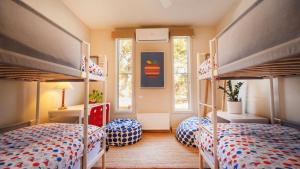 a bedroom with two bunk beds and two windows at Kyarra in Aireys Inlet