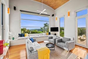 a living room with a couch and chairs and a tv at Kyarra in Aireys Inlet
