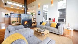 a living room with two couches and a fireplace at Kyarra in Aireys Inlet