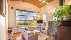 a living room with two couches and a large window at Kyarra in Aireys Inlet