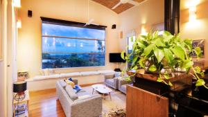 a living room with a large window and a large plant at Kyarra in Aireys Inlet +21 photos