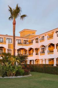 a building with a palm tree in front of it at Palacio de Sancti Petri, a Gran Meliá Hotel - The Leading Hotels of the World in Chiclana de la Frontera