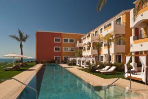 a hotel with a swimming pool next to a building at Palacio de Sancti Petri, a Gran Meliá Hotel - The Leading Hotels of the World in Chiclana de la Frontera