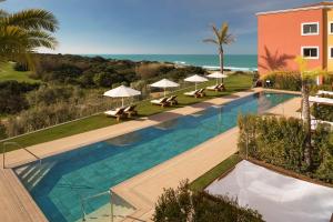 an overhead view of a swimming pool with chairs and umbrellas at Palacio de Sancti Petri, a Gran Meliá Hotel - The Leading Hotels of the World in Chiclana de la Frontera
