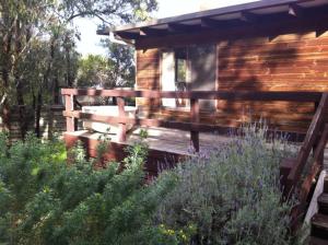 a wooden bench sitting outside of a log cabin at 40 Aireys Street in Aireys Inlet