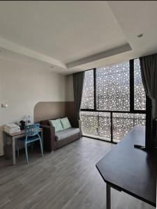 a living room with a couch and a table at Varrzon Residence Srinakarin 56 in Bangna
