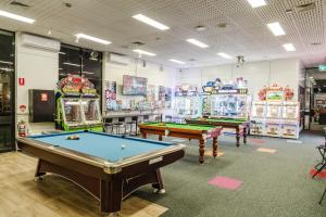 a room with two pool tables and arcade machines at The Reserve Hotel in Sale
