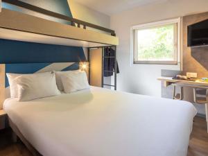 a bedroom with a white bed and a bunk bed at ibis budget Bourg en Bresse in Bourg-en-Bresse
