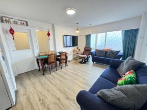 a living room with a blue couch and a table at Delight at Golf in Auckland