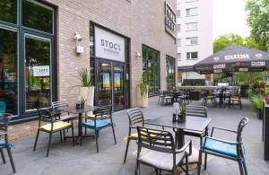 a patio with tables and chairs in front of a store at INNSiDE by Meliá Frankfurt Ostend in Frankfurt