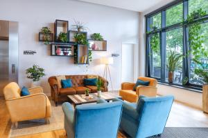 a living room with couches and a table at INNSiDE by Meliá Frankfurt Ostend in Frankfurt