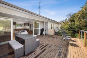 a wooden deck with a kitchen and a living room at Myrtle Cottage in Aireys Inlet