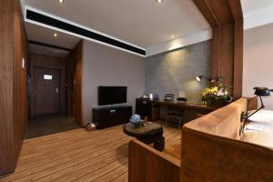 a room with a bed and a desk and a television at MAIHAOHOTELS in Huangdong