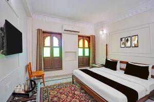 a bedroom with a large bed and a tv in it at Palette Hotel and Resorts Jodhpur Airport Formerly Royale Plazo in Jodhpur